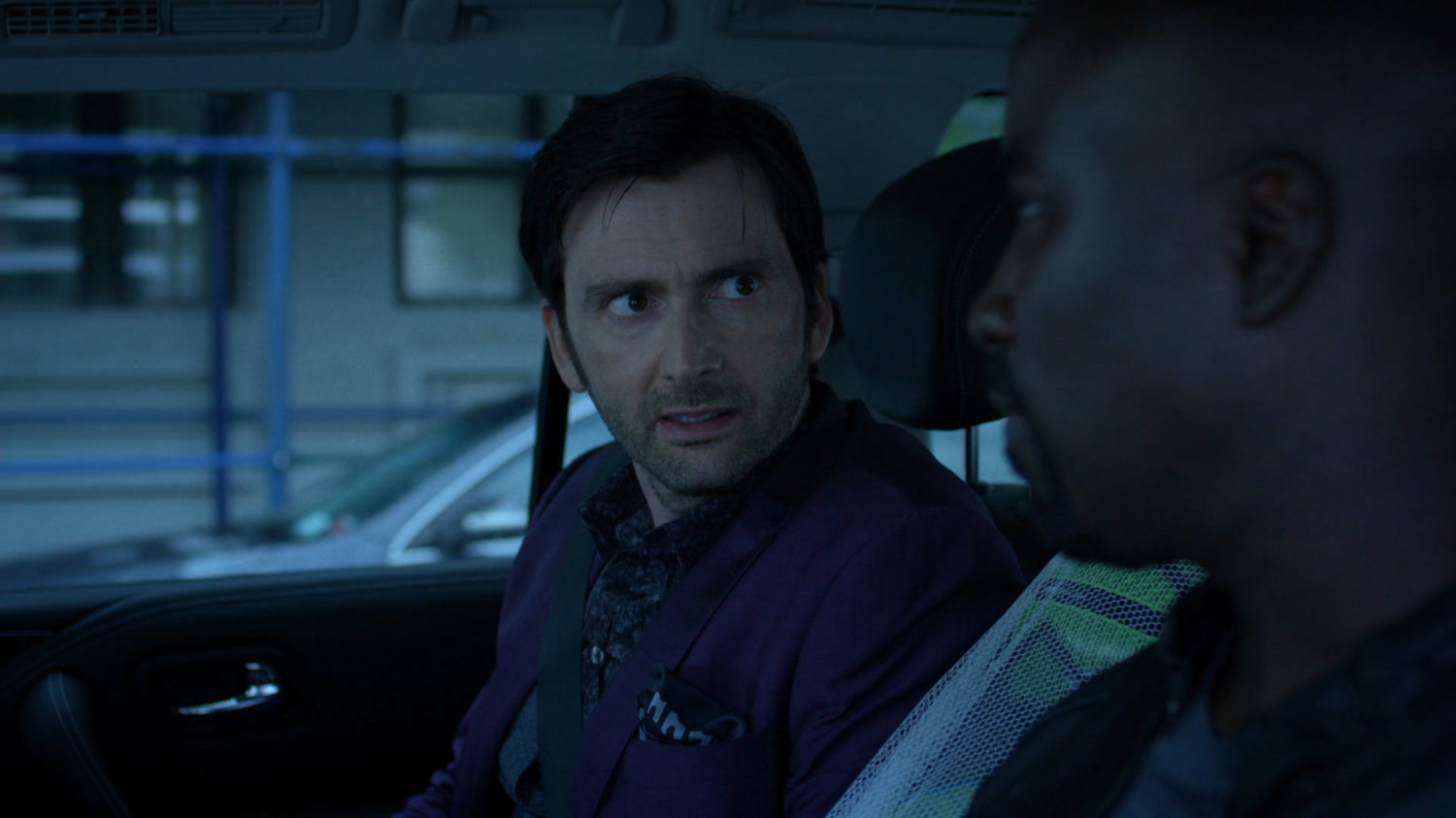 Luke and Kilgrave on back seat of car.