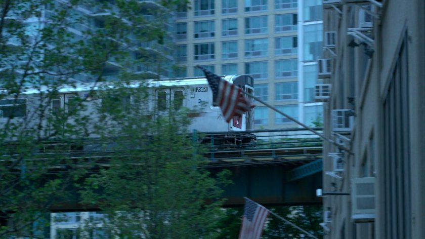 Elevated train traveling behind trees and Zalk Chemical Technologies building