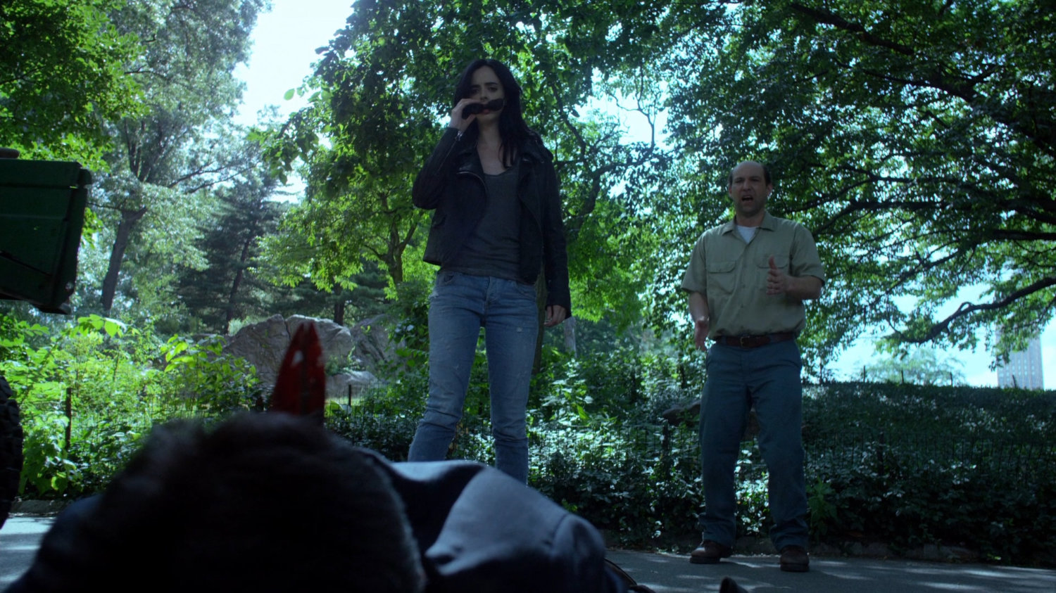 Jessica and gardener look at dead body of Zalk courier.