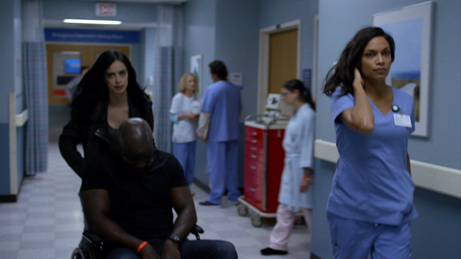 Jessica and Claire wheeling an unconscious Luke down a hallway in Metro-General hospital.