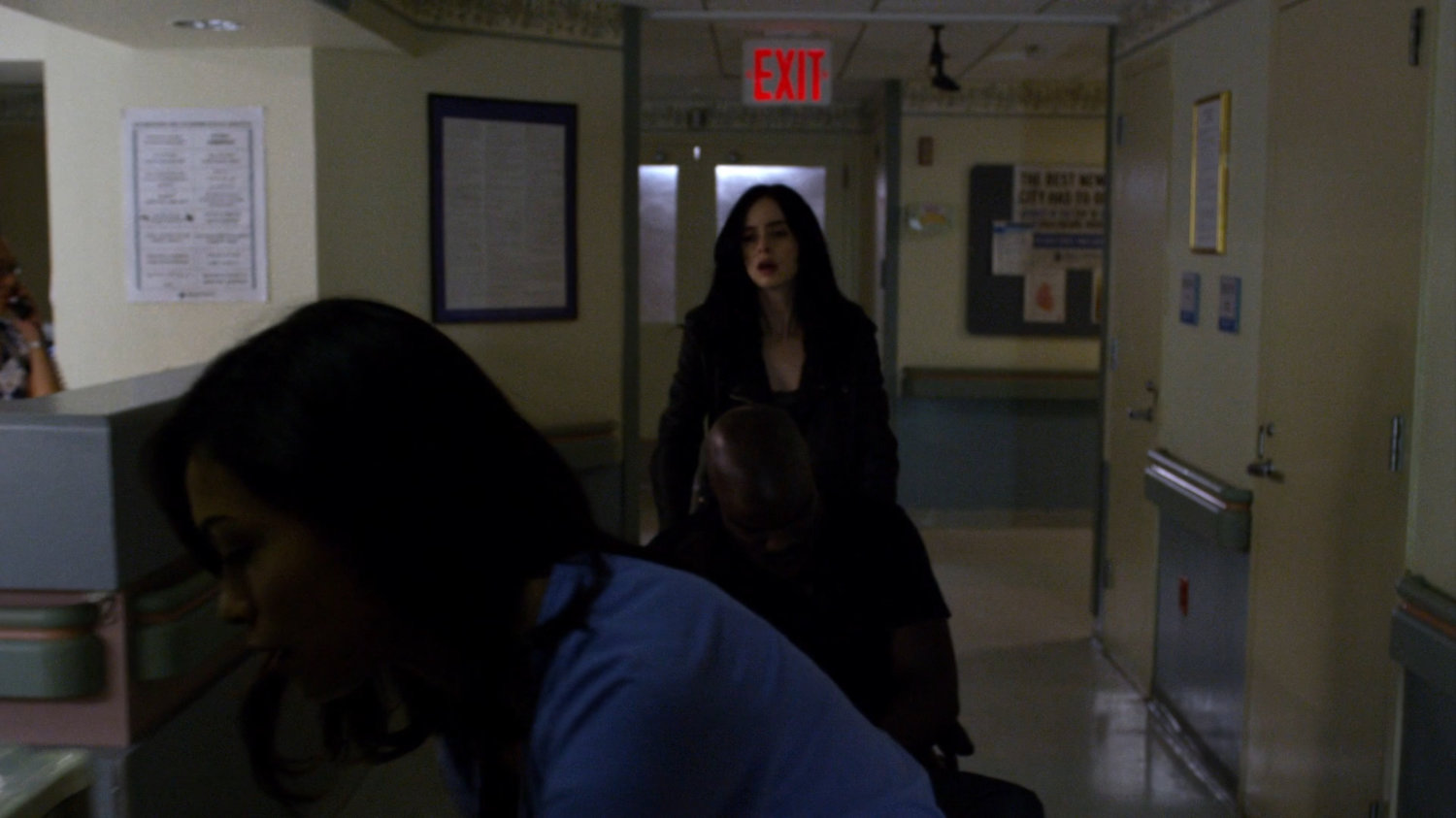Jessica and Claire wheeling an unconscious Luke down a hallway in Metro-General hospital.