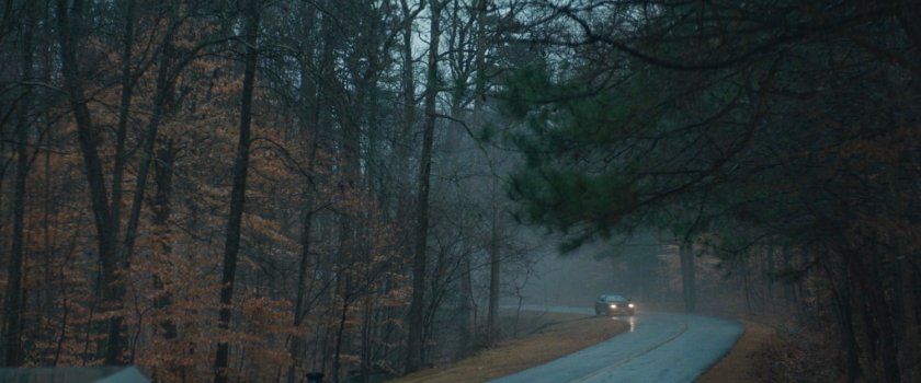 Car driving along road in New Jersey woods.