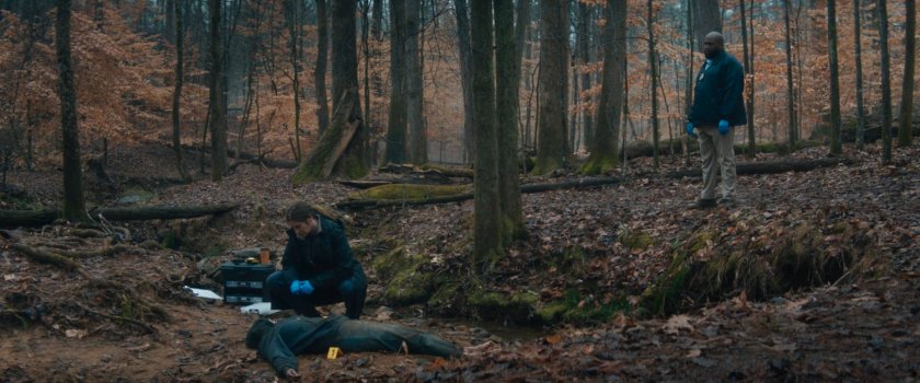 Agnes and Herb looking at body near stream in New Jersey woods.