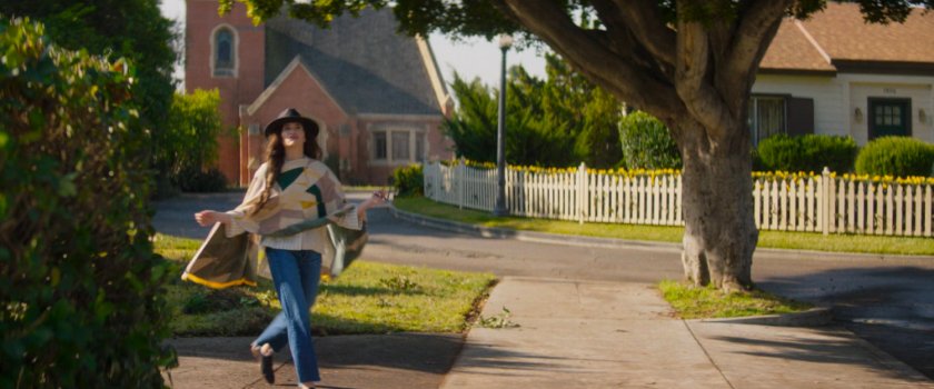 Agatha walking on sidewalk outside her house.