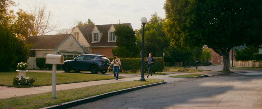 Agatha and teen walking on sidewalk outside her house.