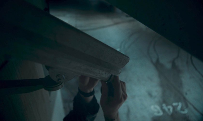 Hands cover a security camera in Eastview parking garage.