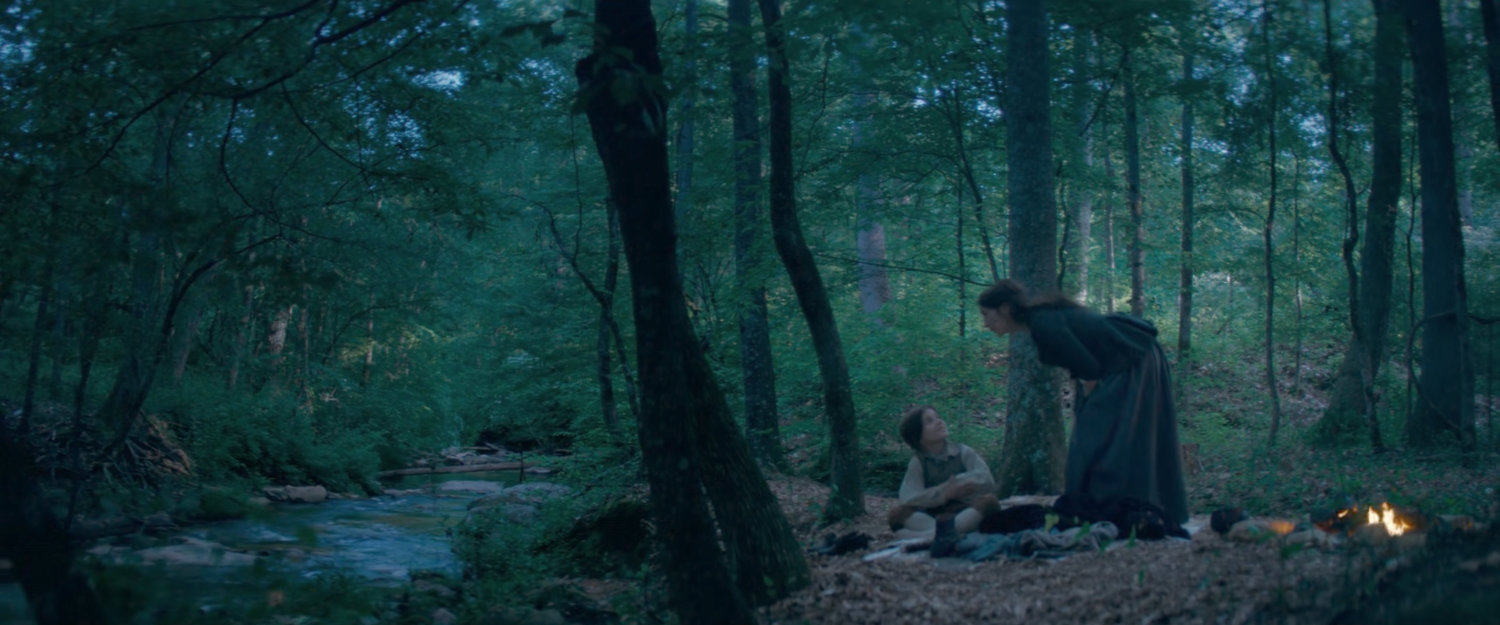 Agatha and Nicky make camp by a river in 1756.