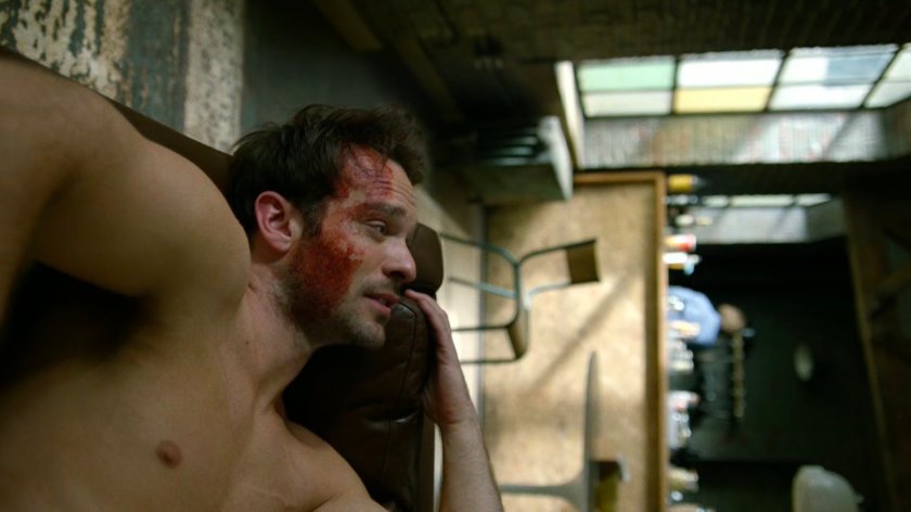 Bloody Matt on a couch in his apartment.