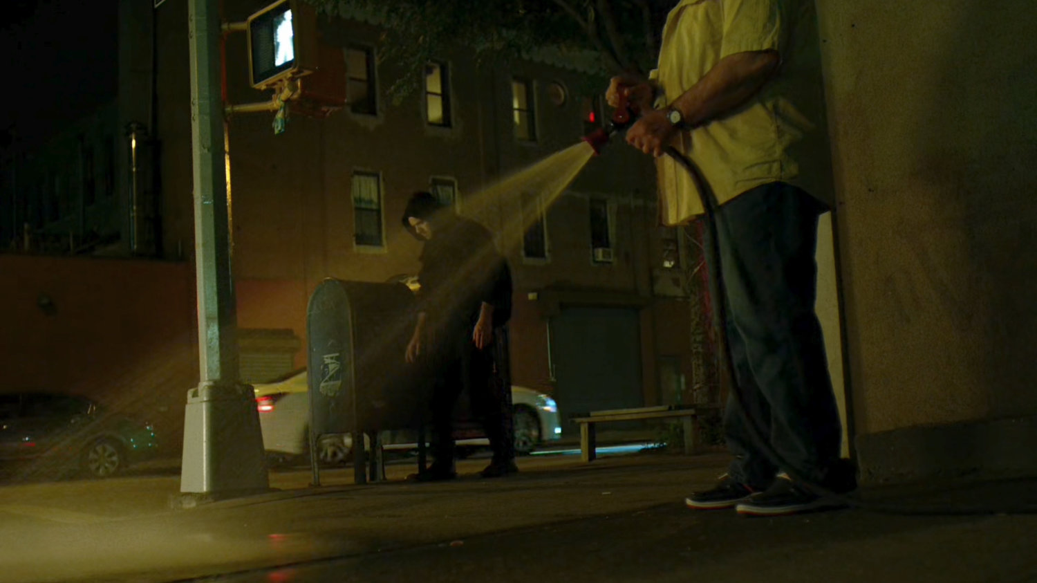 Matt losing the blood trail on a corner where a man is hosing off the sidewalk.