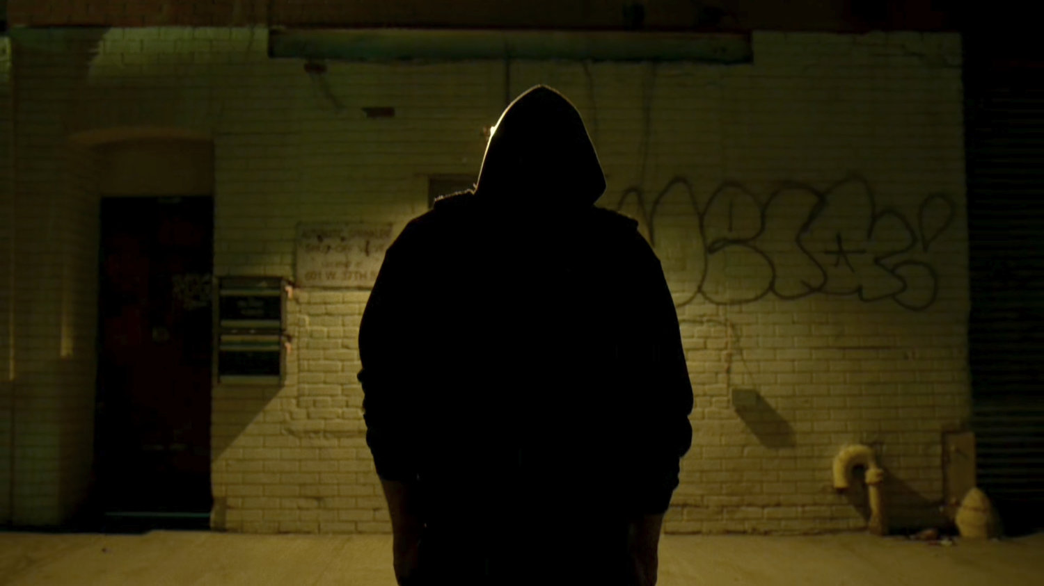 Matt silhouetted by light outside Frank Castle's apartment building.