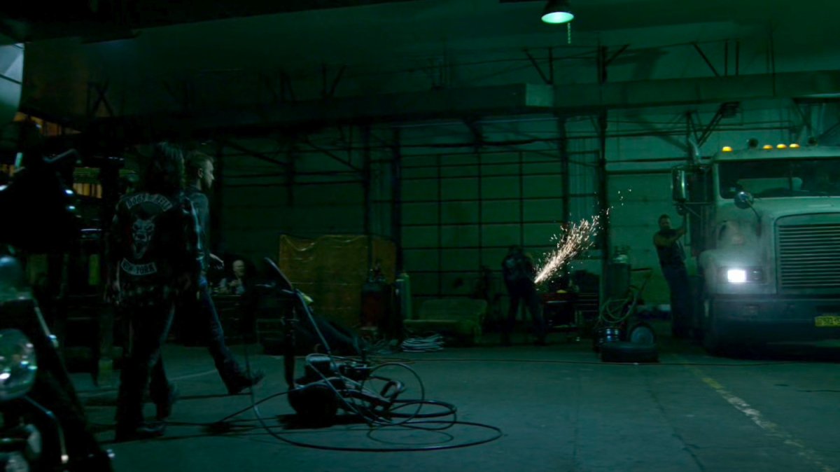 Men cleanup semi truck in Dogs of Hell warehouse.