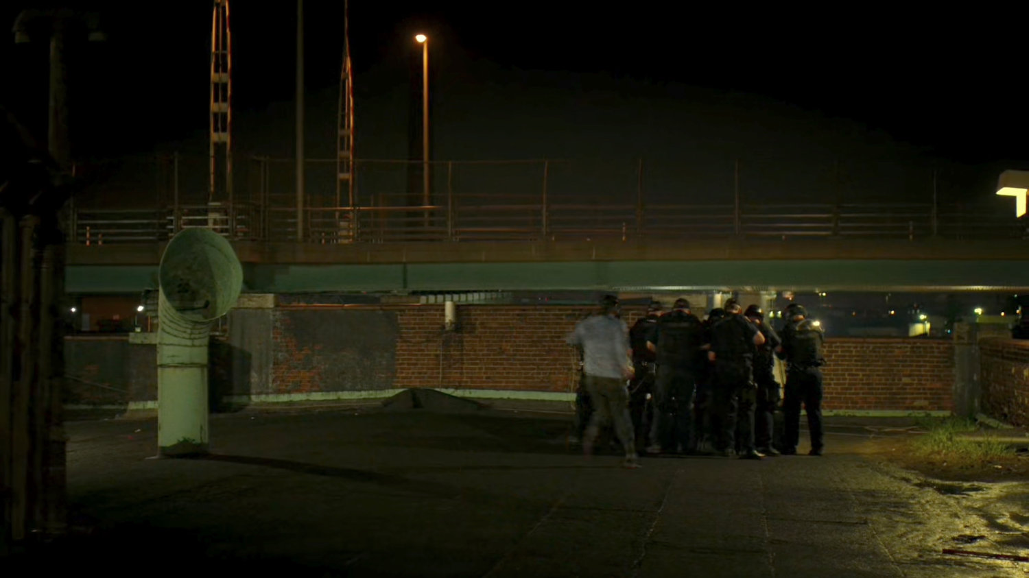 Police gather around skylight on rooftop.