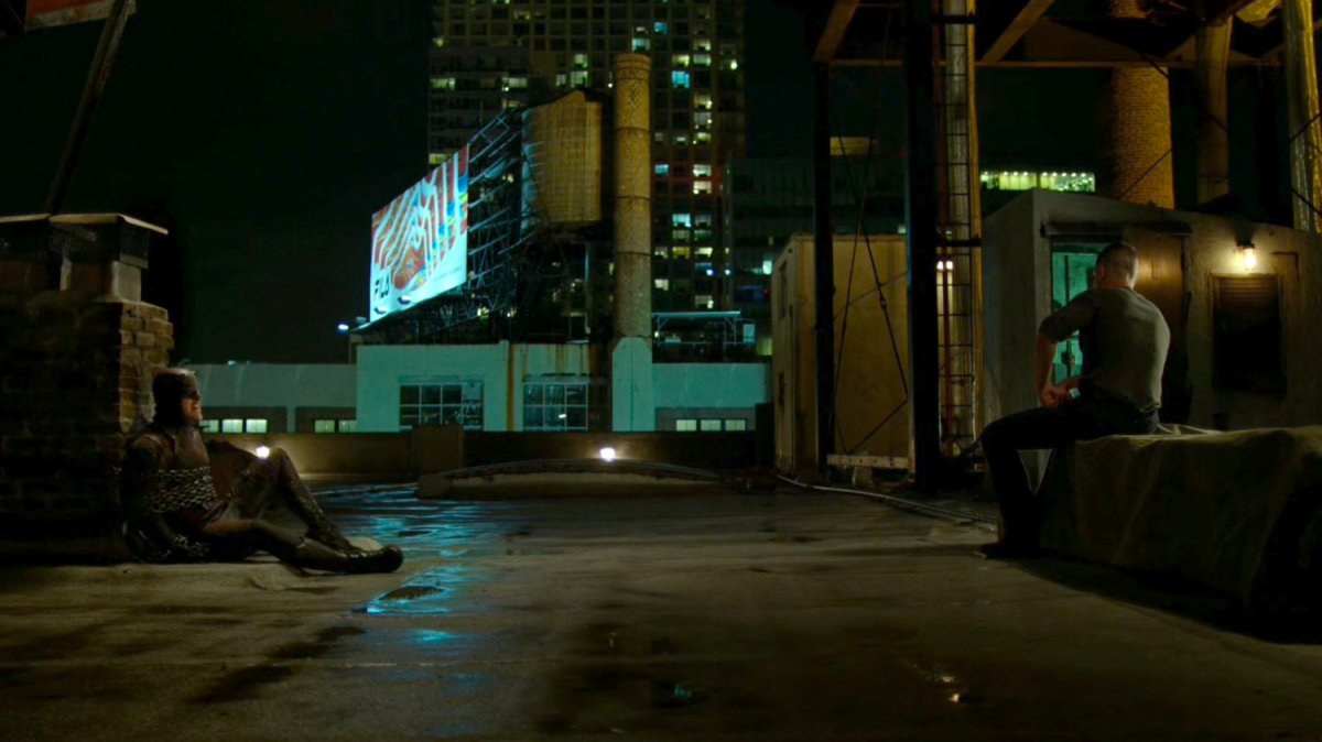 Daredevil chained to a brick smokestack and Frank Castle on rooftop.