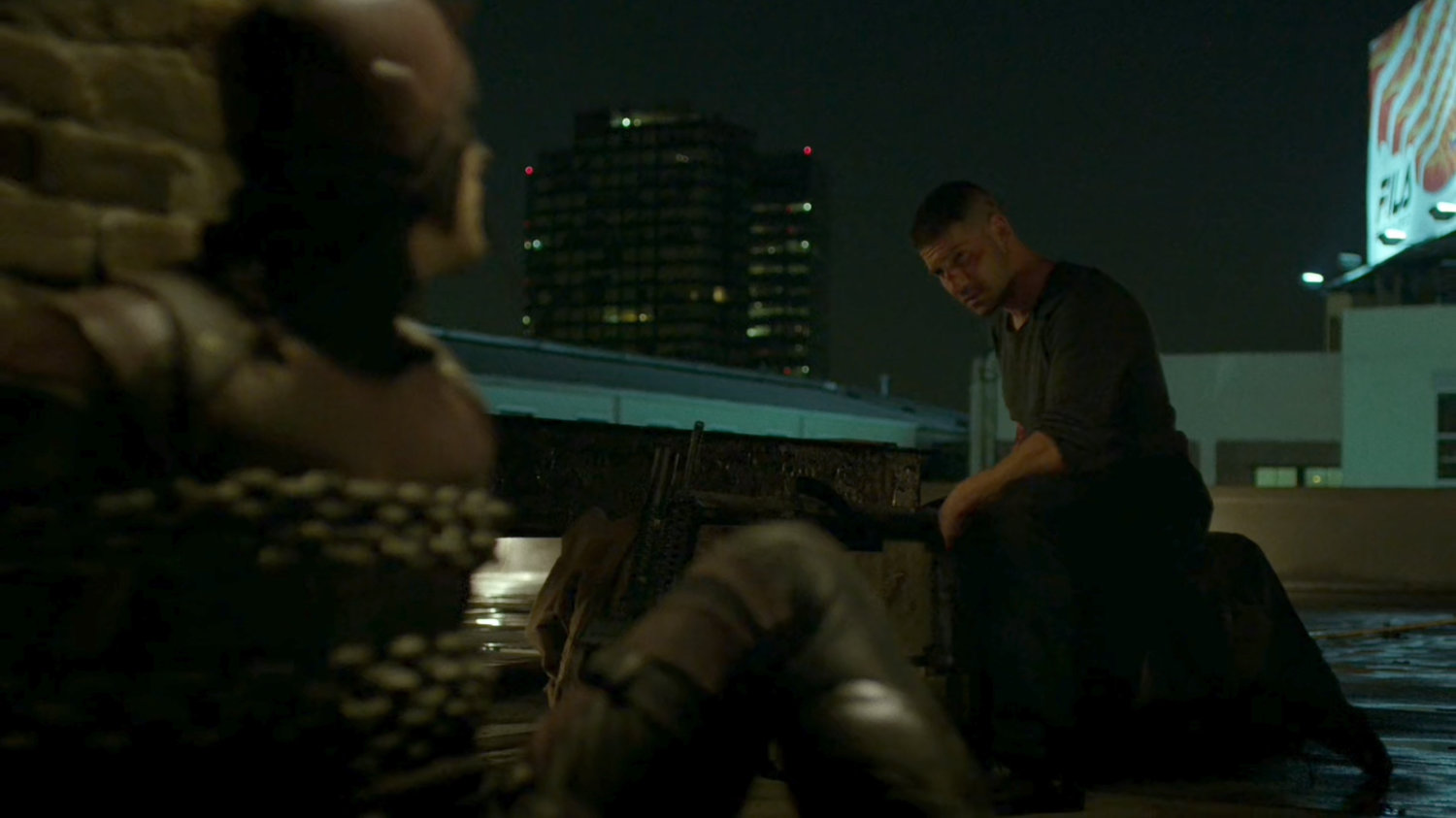 Frank with a chained up Daredevil on rooftop.