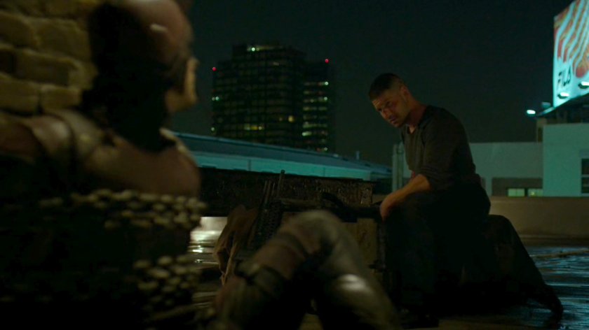 Frank with a chained up Daredevil on rooftop.