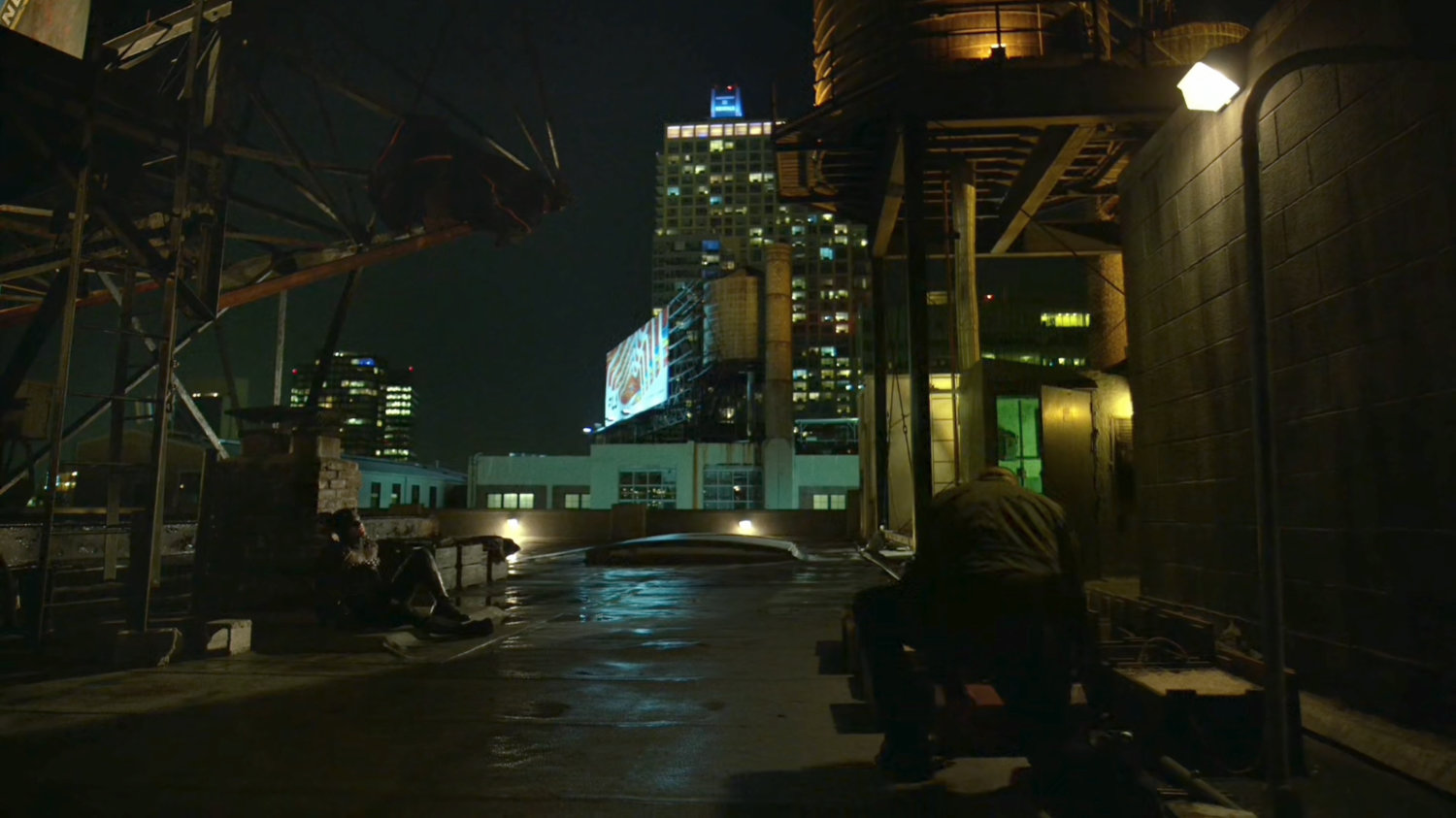 Frank with a chained up Daredevil on rooftop.