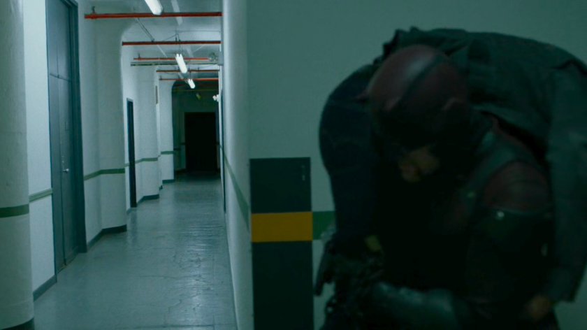 Daredevil carrying Punisher past hallway.
