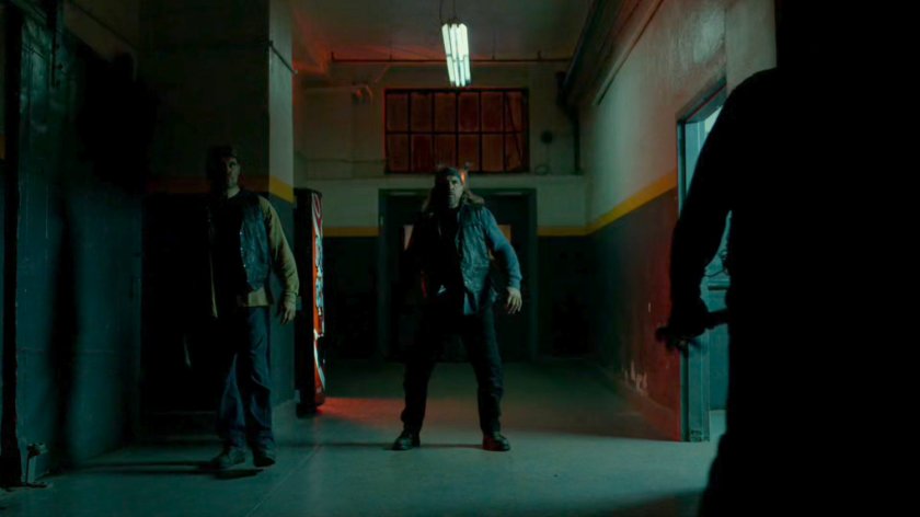 Daredevil confronted by Dogs of Hell gang members in entrance to building.