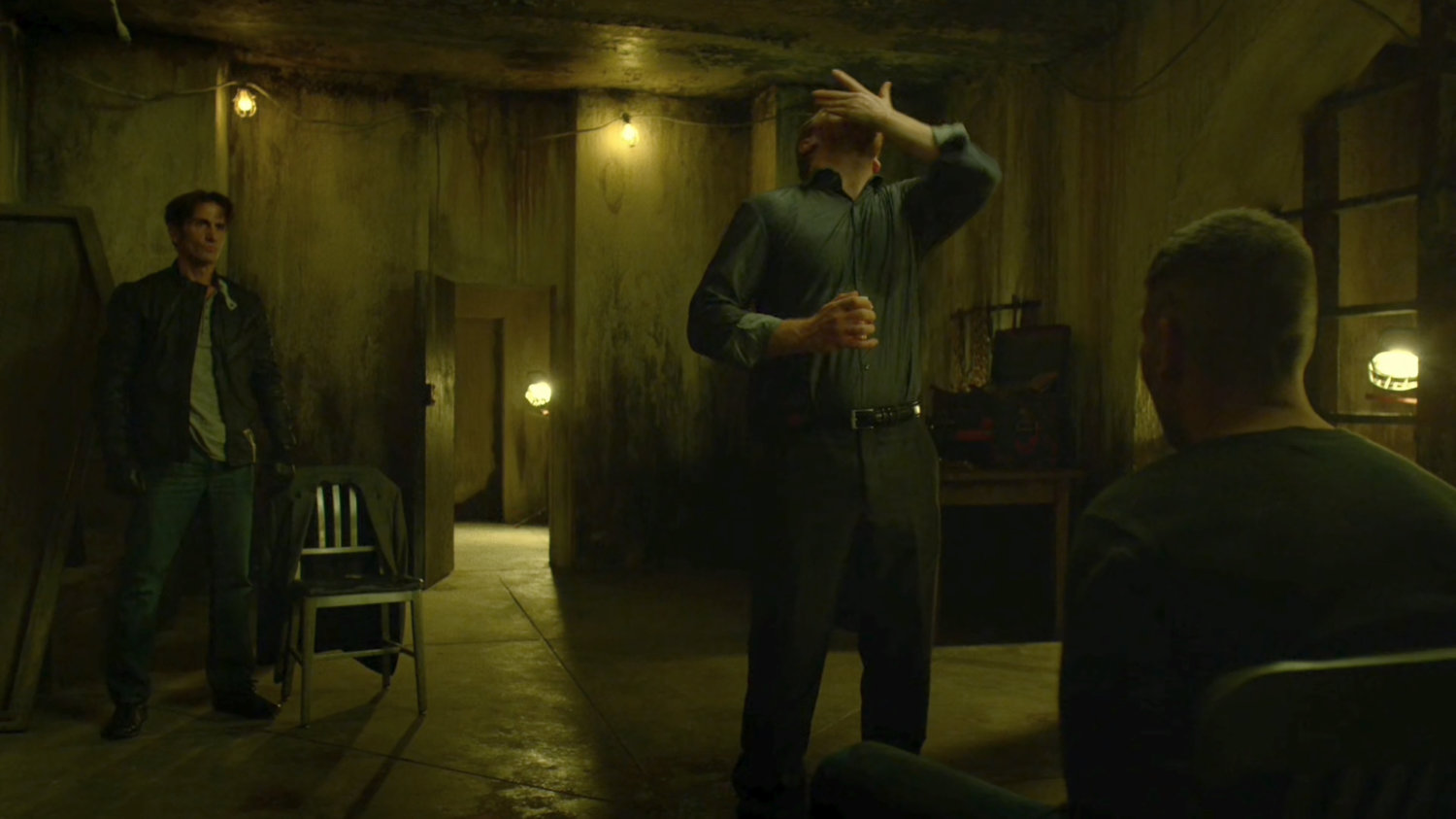 Finn talks to Frank tied to a chair in catacombs.