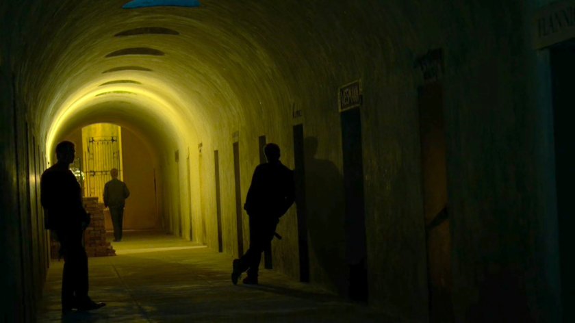 Men in a catacomb hallway