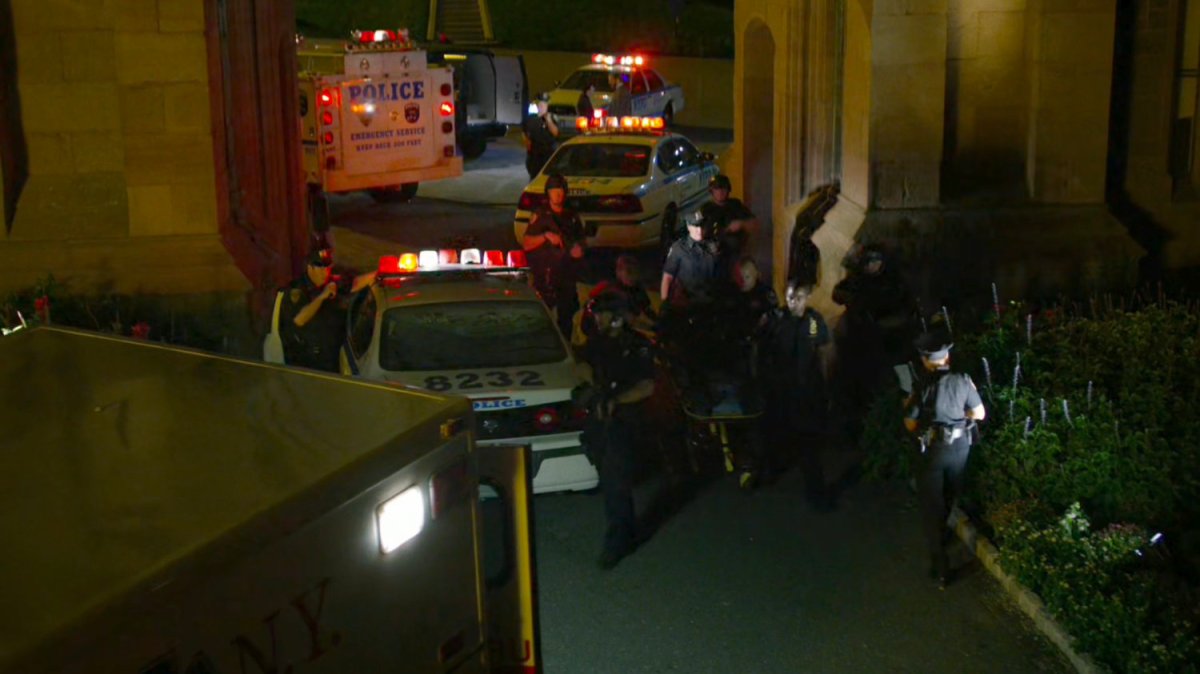 Emergency vehicles and reporters outside gate for St. Michael's Cemetery.