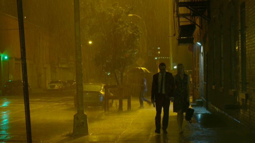 Matt and Karen walking along sidewalk in rain, outside Matt's apartment.