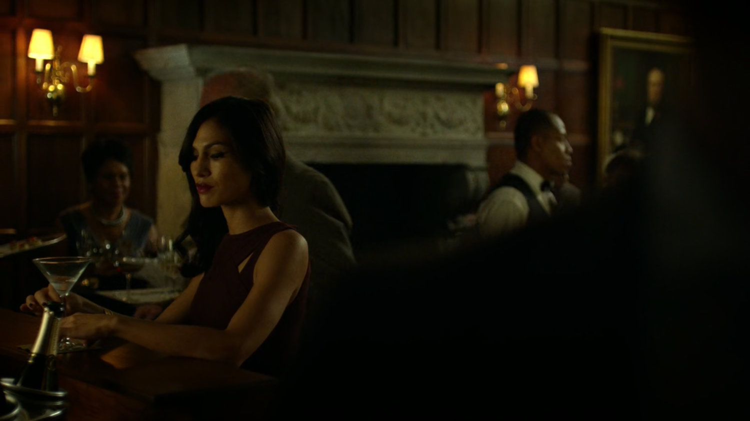 Elektra sitting at the bar in a crowded faculty party.