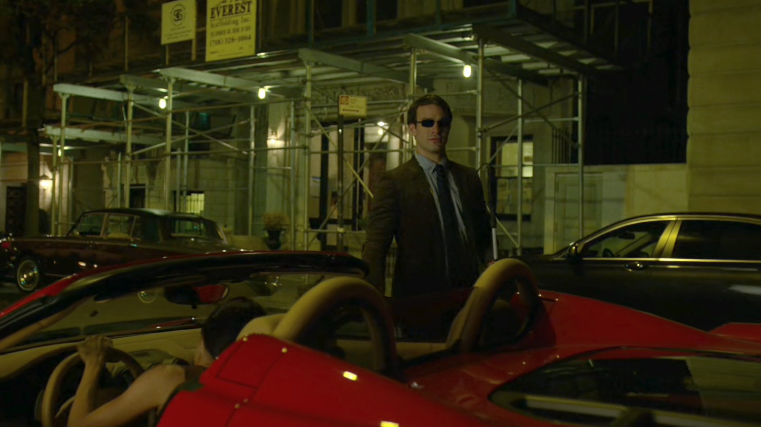 Matt gets into a red sports car parked on the street outside faculty party.
