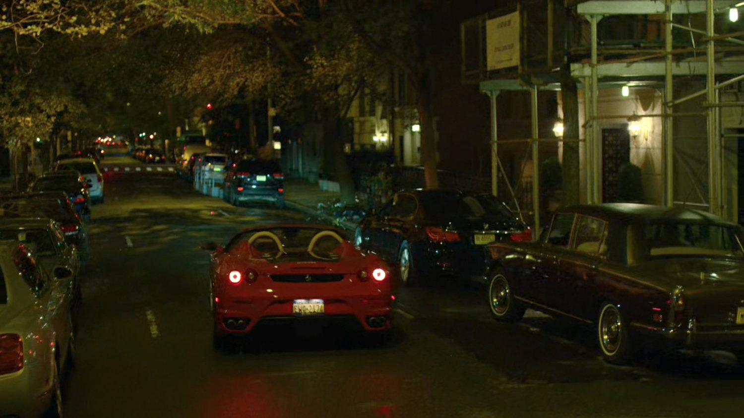 A red sports car drives off outside faculty party.