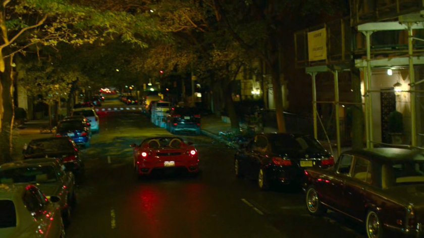 A red sports car drives off outside faculty party.