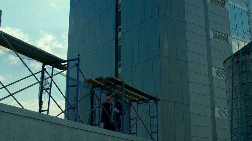 Matt walks through the scaffolding on a roof next to Yakatomi Building.