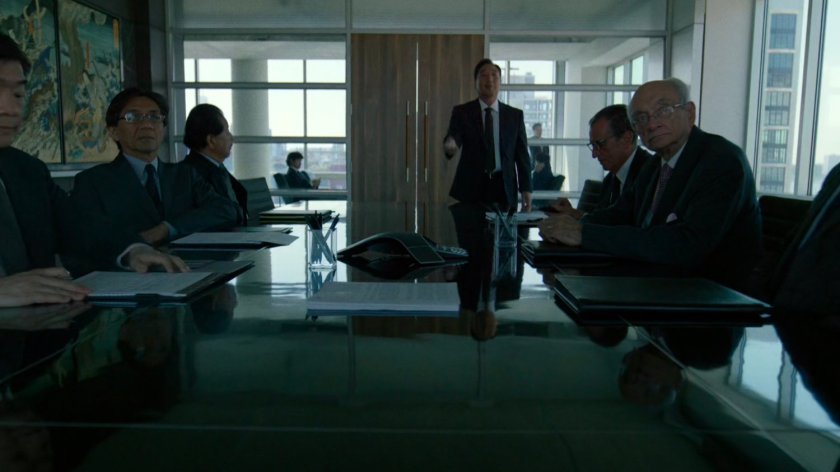 Roxxon board members at a table in the conference room of the Yakatomi Building.