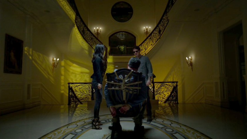 Matt and Elektra standing by Roscoe Sweeney, who is tied up at his mansion.