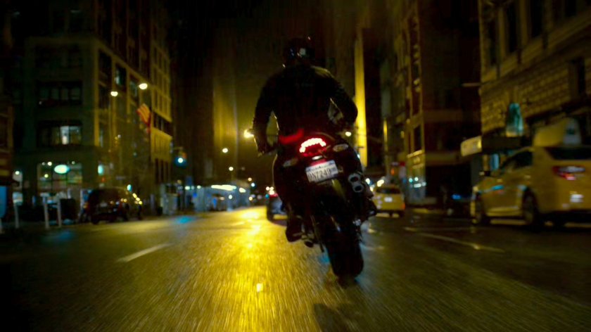 A Yakuza motorcycle rider cruises through a New York street.