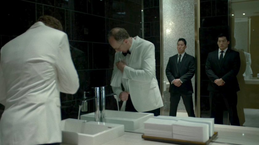 Stan Gibson cleans his jacket in the Roxxon Gala bathroom.