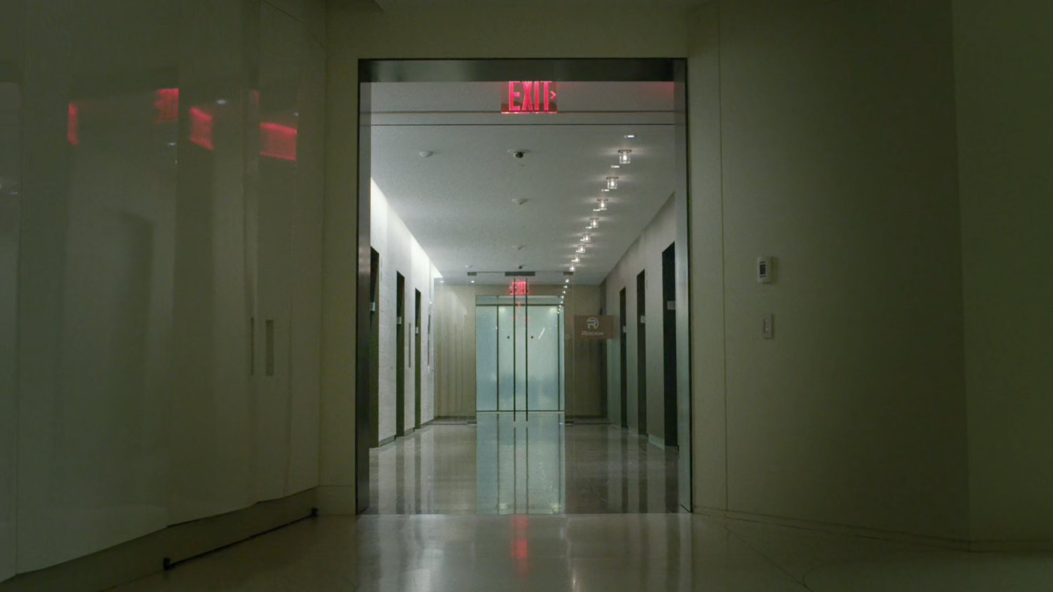 An empty elevator lobby on the 13th floor of the Yakatomi Building.