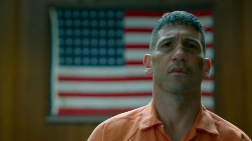 Frank Castle in front of American flag in courtroom.