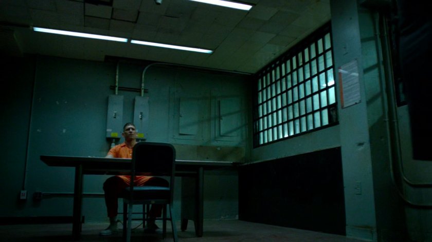 Frank Castle chained to table in conference cell.