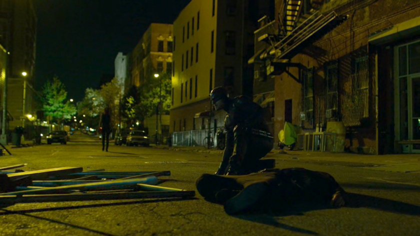 Daredevil kneeling by unconscious guard outside Midland Circle construction site.