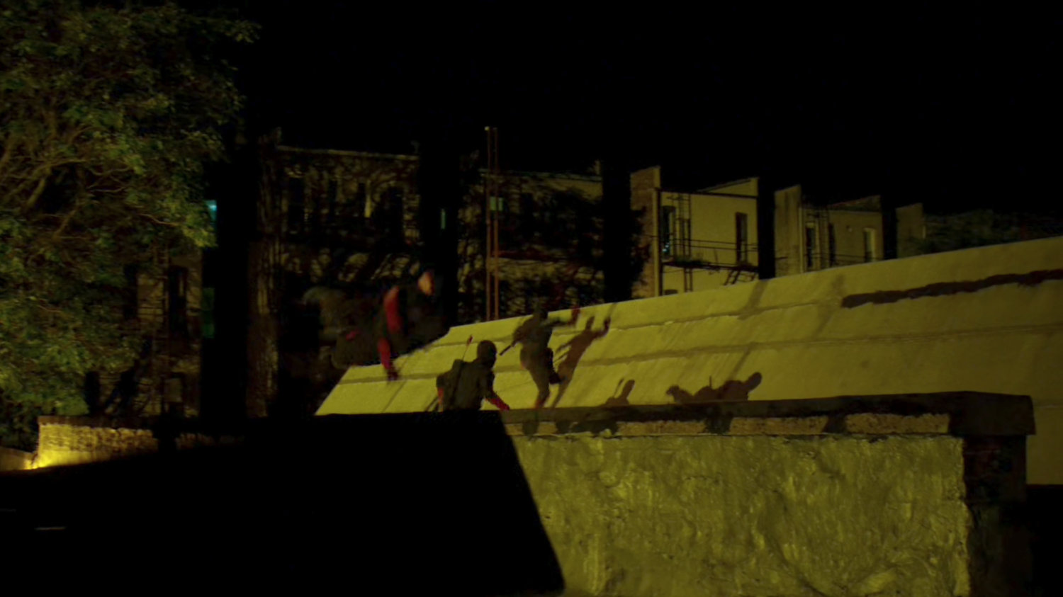 Ninjas from the Hand run across the rooftops at night.
