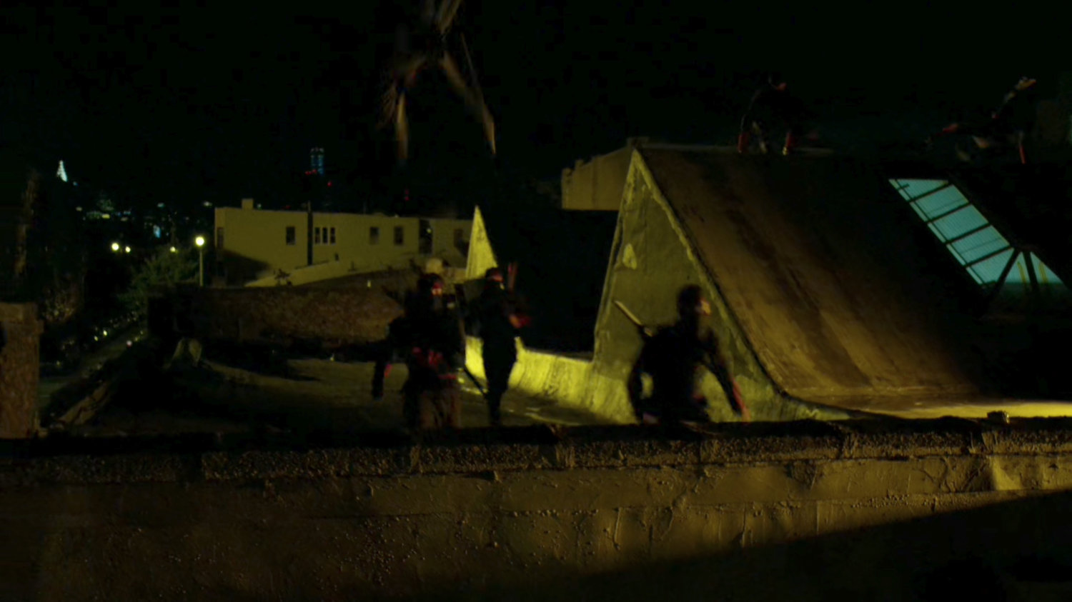 Ninjas from the Hand run across the rooftops at night.