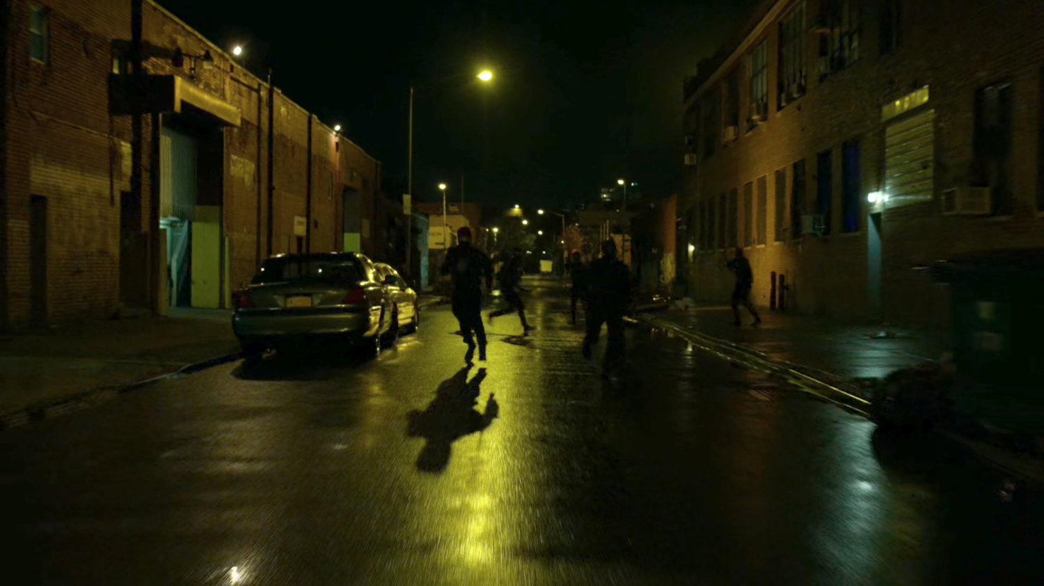 The Hand ninjas run along street at night.