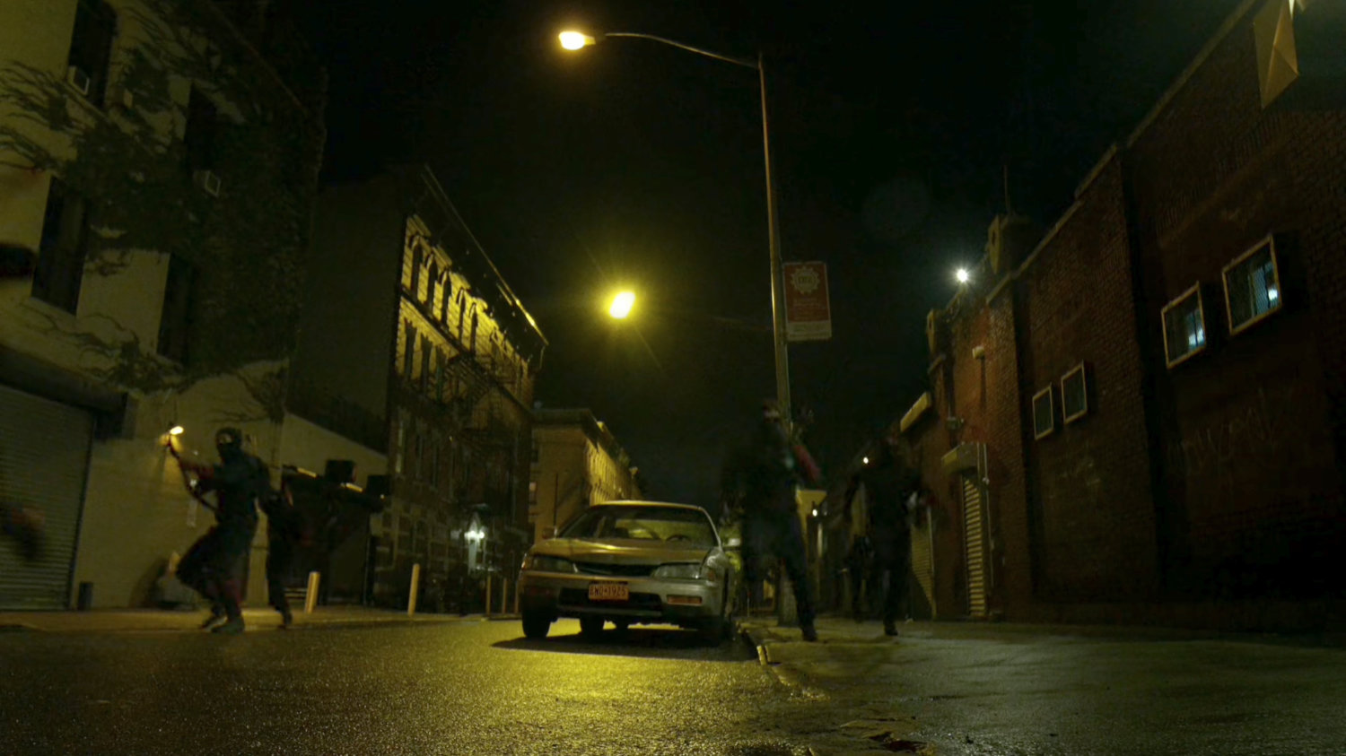 The Hand ninjas run along street at night.