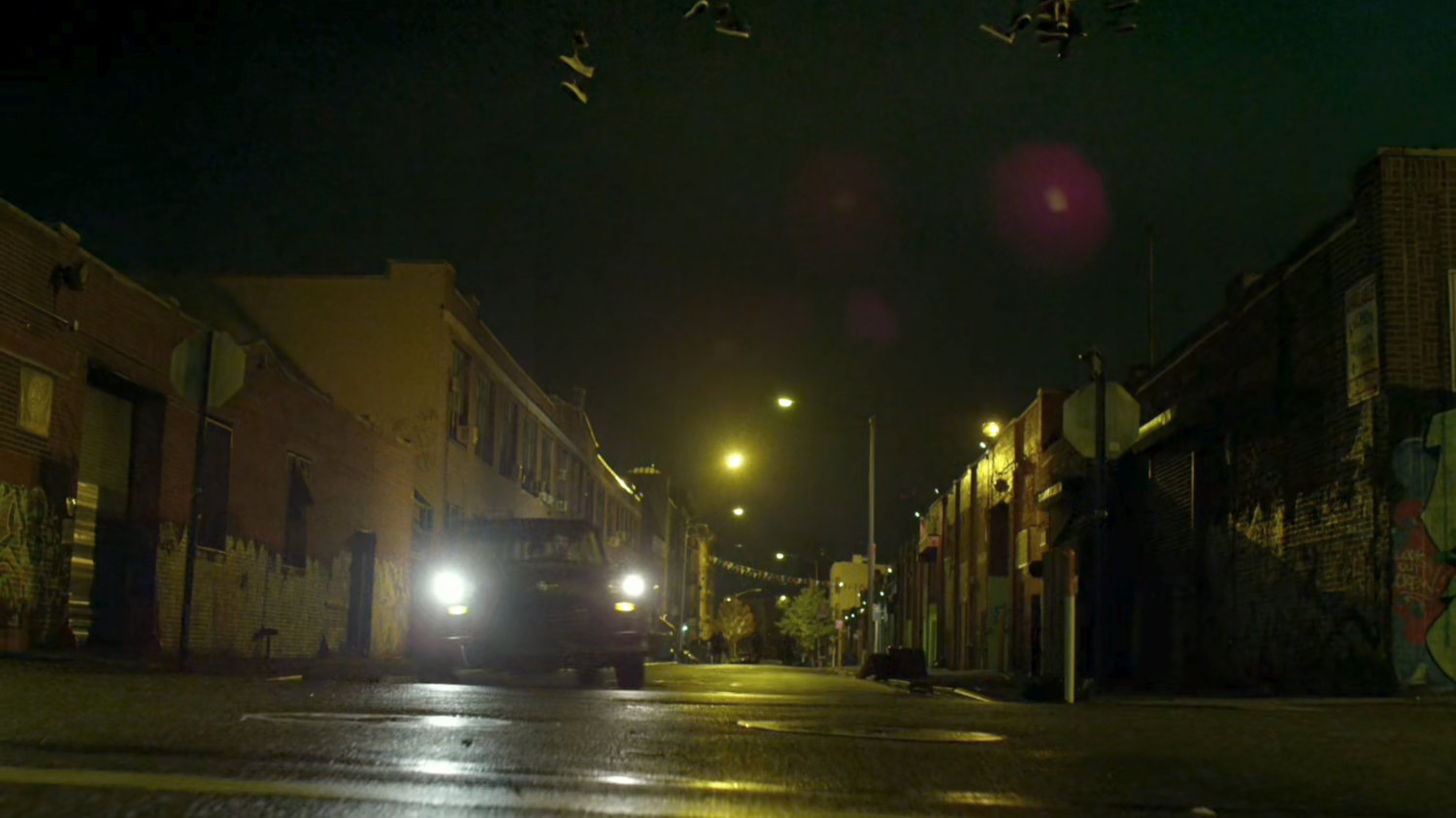 Stick's car corners on a narrow street at night.