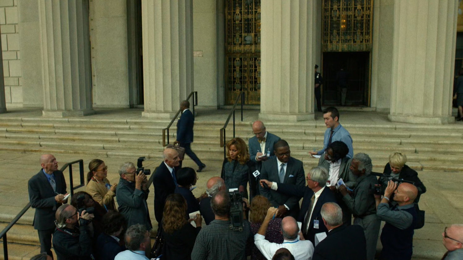 DA Reyes and ADA Tower standing outside the courthouse surrounded by reporters.