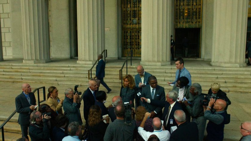 DA Reyes and ADA Tower standing outside the courthouse surrounded by reporters.