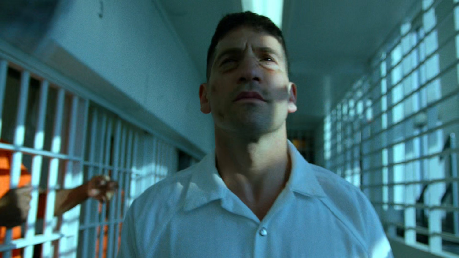 Frank walking along prisoner hallway in Ryker's Island correctional facility.
