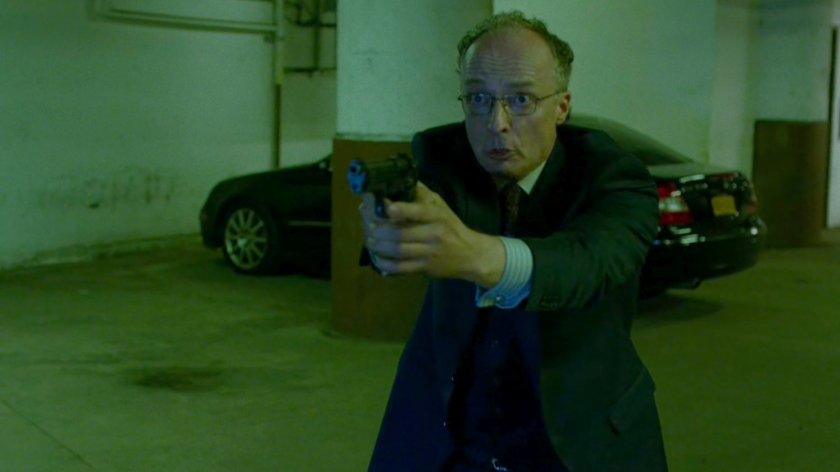 Stan Gibson holds a gun on Daredevil in Yakatomi parking garage.
