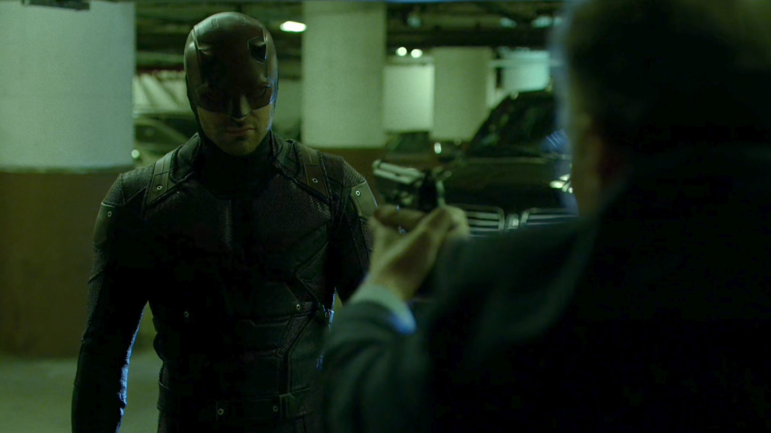 Stan Gibson holds a gun on Daredevil in Yakatomi parking garage.