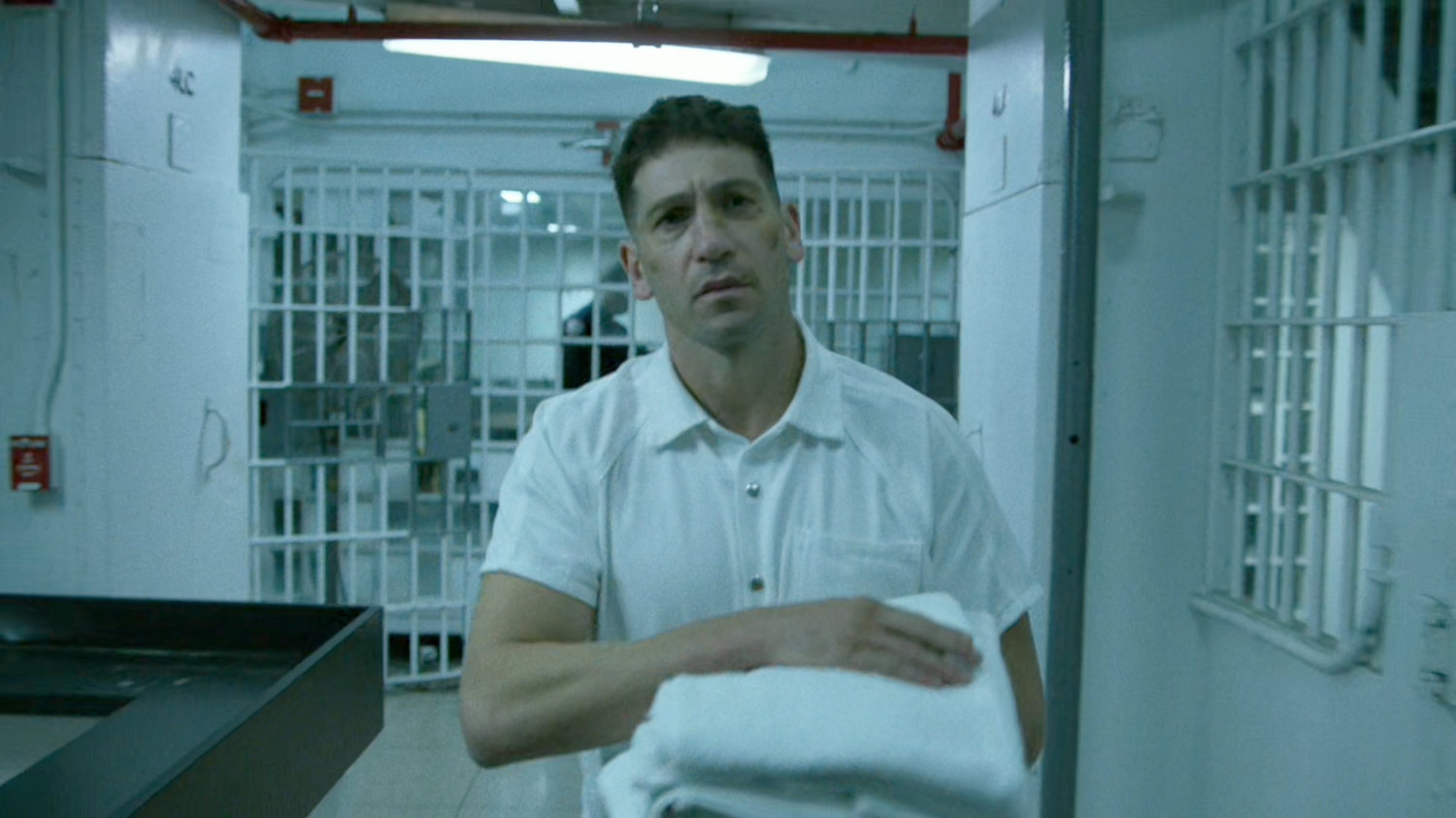 Frank Castle walking through prison hallway at Ryker's Island correctional facility.